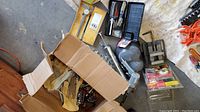 Photo of box with work gloves, various hand tools including wrenches, sockets and screwdrivers