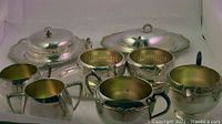 11-piece E.P. Silverware lot including cream and sugar sets, butter dishes, and a tray arranged in a group view showing all items.