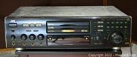 Front view of JVC XL-MV303 karaoke machine showing disc drives, cassette deck, microphone inputs, control buttons, and numeric keypad.