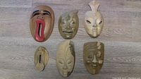 Overview of all six wooden masks/ wall art laid out on floor