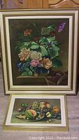 Framed oil painting of floral arrangement on canvas with various flowers against dark background.