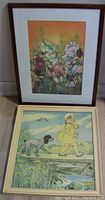 Two framed prints stacked, one with floral pastel, the other showing a girl and dog near water.