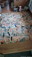 Full view of the large quilt spread on the floor, showing the overall patchwork pattern and condition.