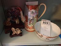 Photo showing Satsuma chocolate pot, chrysanthemum bowl, animal figurines on wood stands and decorated Asian plate.