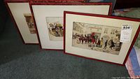 Three framed vintage Dickens coaching prints displayed together against carpeted floor, showing their full wood frames and mats.