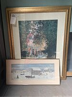 Photo showing both framed primitive art paintings signed by John Colquhoun, one large with gold frame and one smaller with beige frame, placed against a wall.