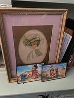 Framed Gibson Girl theme wall art with two small framed watercolor paintings leaning in front