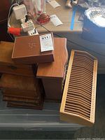Multiple antique and vintage wood boxes with brass finishes, one leather box on top, with wooden bill organizer next to them.
