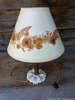 Full view of antique milk glass table lamp with floral fabric shade and old cord.
