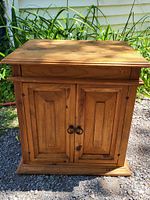Front view of the 1970s Mexican pine washstand showing the drawer and double doors with metal ring handles.