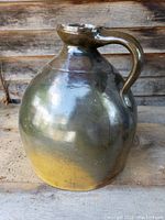 Front view showing jug form, handle, and imperfect lip edges with minor chipping.