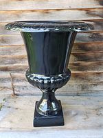 Side view of black fiber Grecian urn planter showing its shape and pedestal base