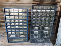 Two metal cases side by side containing many clear plastic drawers labeled with various hardware items and numbers.