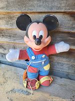 Front view of the vintage Mickey Mouse plush showing educational features with buttons, zipper and shoelace details.