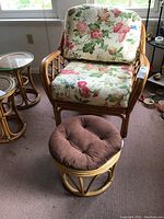 Braxton Culler chair with floral fabric upholstery and rattan frame, paired with matching rattan foot stool with brown tufted cushion
