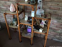 Wooden three tiered plant stand with hexagonal tiles, shown with various items on it (not included). Fit for displaying plants or decor.