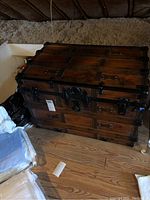 Wide view showing full trunk in attic corner with angled ceiling and wooden floor