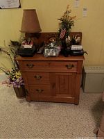 Full view of vintage wooden washstand showing overall design, size and finish with various items on top.
