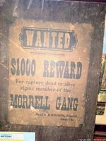 Front view of antique wanted poster mounted on wood, featuring $1000 reward for Morrell Gang capture, with visible aged paper and wooden backing.