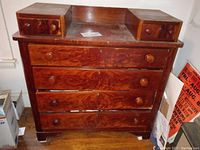 Full front view showing four large drawers and two smaller top drawers with round wooden knobs, as well as visible scratches and wear on wood surface.