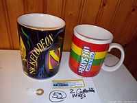 Front view of the two collectible mugs placed side-by-side showing the Nickelodeon and Lifesavers Korea designs