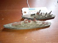 Top-down view of two vintage Tootsie Toy battleship diecast ships showing wear and detail