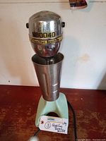 Front view of vintage Hamilton Beach mixer with metal mixing cup installed on top, showing model number N80040.