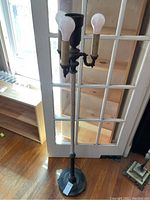 Full view of the antique metal floor lamp showing the tall slender base, round metal bottom, and four lightbulb sockets including three standard and one mogul size socket.