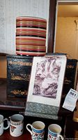 Lacquered wood storage box with the silk scroll hanging in front and bento bowls stacked on top
