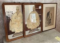 Two framed reverse painting mirrors of a Chinese Emperor and Empress, next to a framed Asian painting with calligraphy.