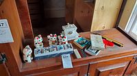 Wide view of all lot items arranged on a wooden surface including Maneki-Neko cats and tea set.