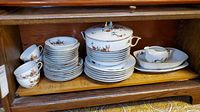 Photo of stacked dinnerware and serving bowl showing overall set contents and condition