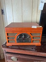Front and top view of the vintage Crosley retro turntable stereo with wooden cabinet, metal front plate featuring retro knobs and speaker grills. Visible wear on wood.