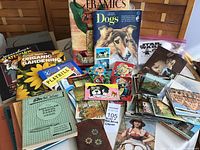Photo of assorted postcards, books including gardening and dogs care, Star Wars crochet kit, greeting cards, and metal bucket