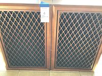 Front view of pair of Sonics wooden cabinet speakers with lattice grille covering the speaker areas.