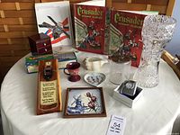 Full view of lot showing stamp albums, vase, small cup, tile, vanity jar, clock in box, wooden trinket box, and other items.