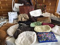 Overview of 18 vintage purses in various styles and colors, displayed overlapping on a white fabric surface