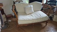 Full view of the Highland House daybed with cream cushions inside a room showing its overall shape and style.
