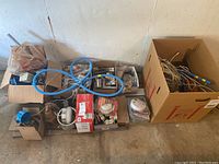 Wide view showing multiple boxes and bags containing electrical supplies including wires, sockets, light fixtures, and fire alarms.