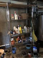 Full view of the chrome adjustable shelving unit with storage items currently on the shelves, showing the general size and condition of the shelving unit.