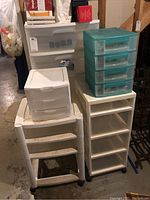 Overview of six plastic storage units of various sizes and drawer configurations, grouped together showing condition and variety.