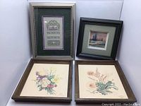 Set of four framed artworks including two flower prints, an embroidery wall art, and a watercolor painting.