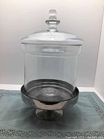 Front view of the glass jar with lid on metal stand