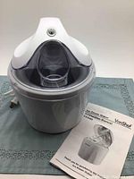 VonShef ice cream maker unit with lid and instruction manual on a blue cloth.
