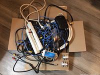Photo of tangled cords, power strips, audio/video and coaxial cables as well as connectors.