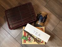 Photo shows the bamboo storage box labeled TEA, pottery vase and some additional items on a wooden floor