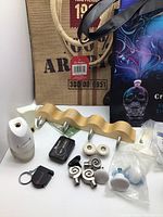 Lot items arranged with air freshener, flashlight, drawer knobs, hooks, and tote bags visible