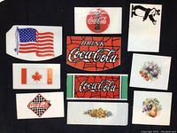 Top view of various stained glass pieces including Coca-Cola logos, flags, floral, fruit, and dancing bear designs.
