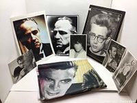Full view of all postcards arranged around folded flag showing vintage portraits of actors and musicians.