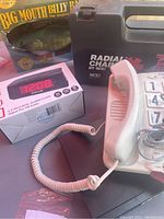 Clarity telephone, digital alarm clock, Big Mouth Billy Bass fish box, tire chains case